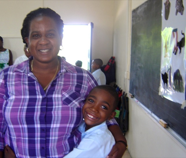 Teacher and student, with Cat Behaviour pster on the blackboard. The poster is used to demonstrate cat body language and to later quizz the students