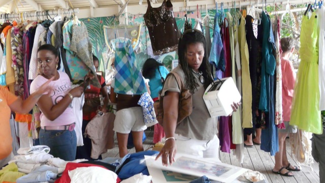 A woman holds a toaster while shopping This photo shows people participating in one of our yard sales