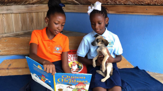 Students from Omololu International School read to AARF puppies