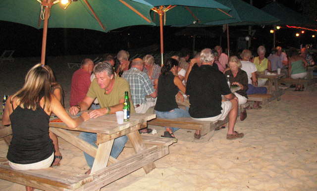 Bingo players at tables on the beach