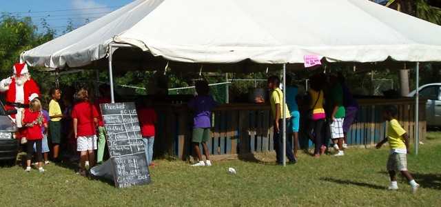 A photo showing one of the tents at the fair. At the left is Santa, with children grouped around him