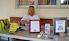 Suzie sits at a table in front of the Post Office to sell memberships and AARF goods