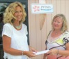 Jan, from Petals Boutique hands a donation check to Lisa