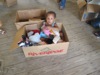 A child takes a time out in a box while mother shops